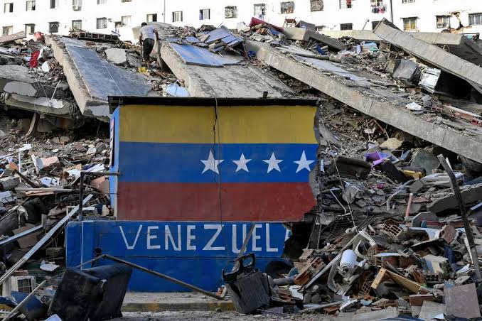 Bandeira da Venezuela pintada sobre destroços de prédio desabado em La Guaira, uma semana após os terremotos