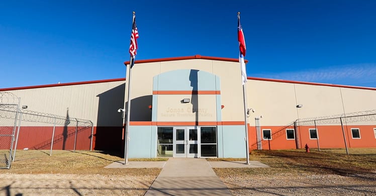 Fachada de um centro de detenção no Texas, com bandeiras dos Estados Unidos e do estado