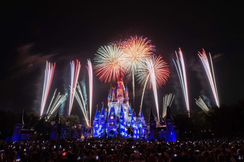 Fogos de artifício vermelhos, brancos e azuis sobre o castelo da Cinderela no Magic Kingdom, em Orlando, diante de multidão