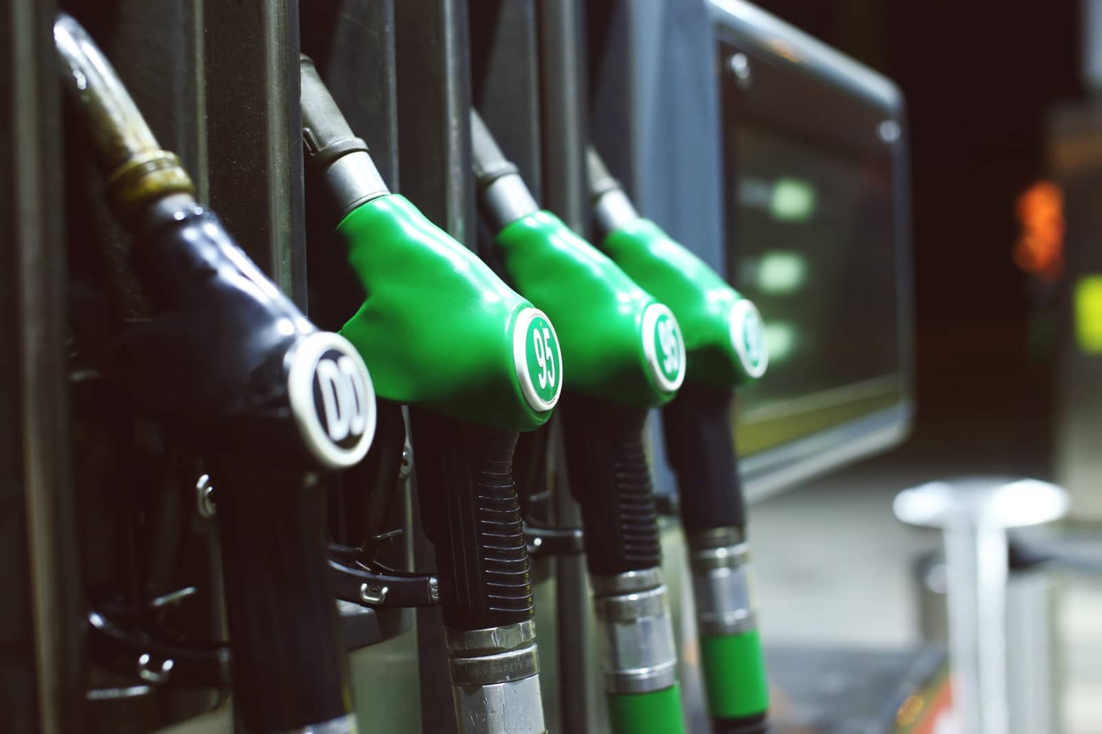 Bicos de bomba de combustível, um de diesel e três de gasolina, em um posto