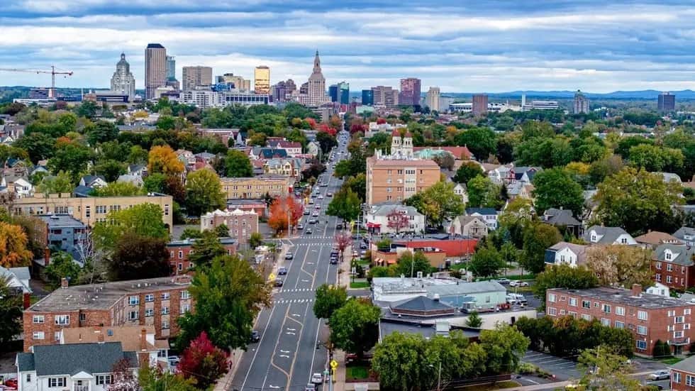 Vista aérea de Hartford, Connecticut, com avenida arborizada em primeiro plano e prédios do centro da cidade ao fundo