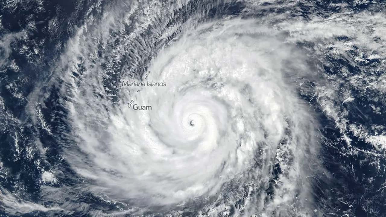 Imagem de satélite do supertufão Bavi, com o olho bem definido sobre o Pacífico Ocidental e as ilhas de Guam e das Marianas identificadas