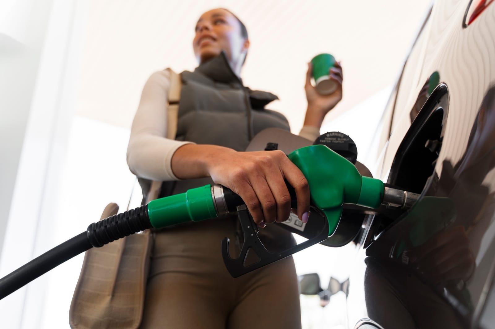 Pessoa abastecendo o carro numa bomba de gasolina
