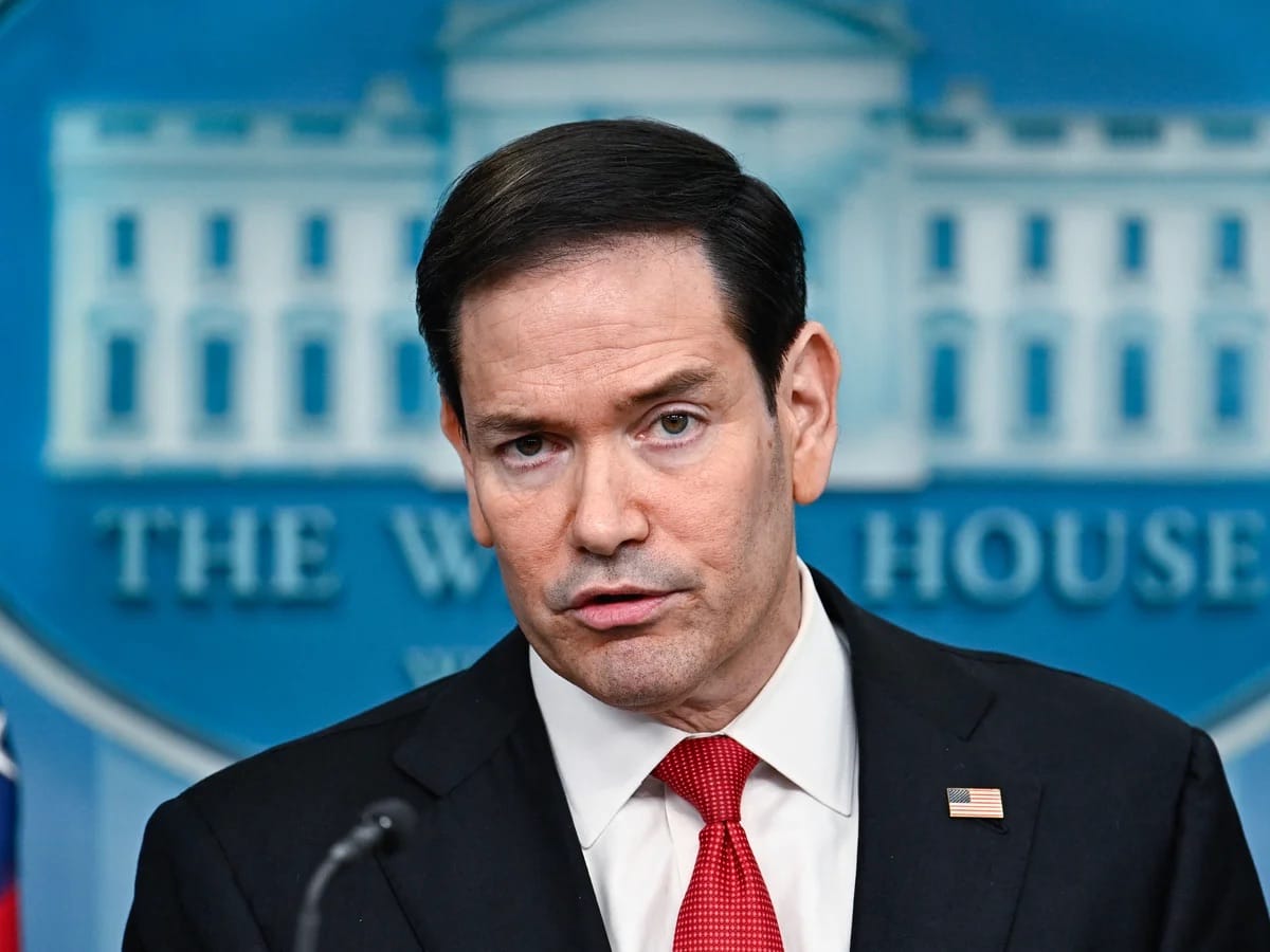O secretário de Estado Marco Rubio, de terno escuro e gravata vermelha, fala ao microfone na sala de imprensa da Casa Branca, com o emblema do prédio ao fundo