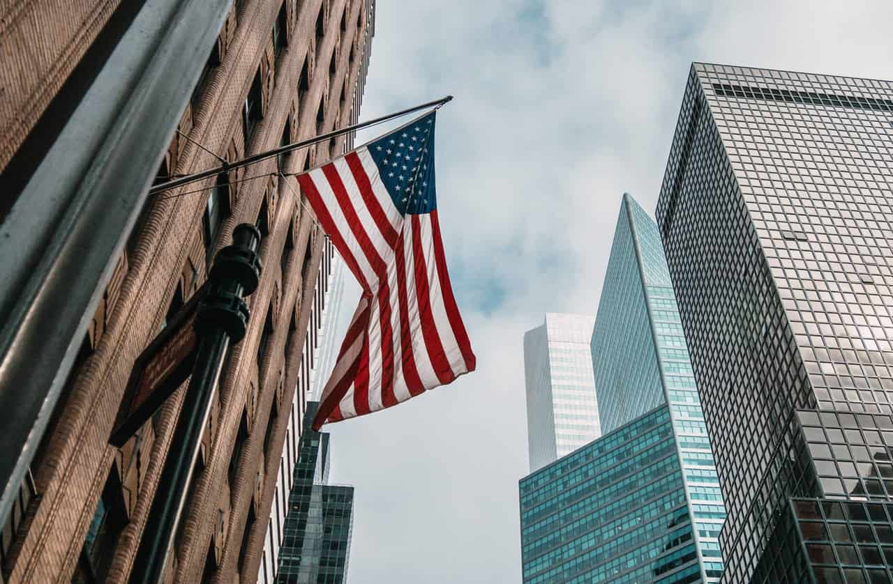 Bandeira dos Estados Unidos vista de baixo, ao lado de prédios comerciais