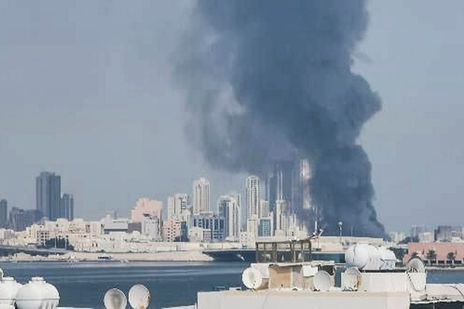 Coluna de fumaça escura sobe sobre prédios à beira-mar em Manama, no Bahrein, após ataque iraniano