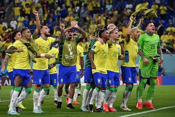 Jogadores da seleção brasileira, de uniforme amarelo e verde, comemoram em campo diante da torcida