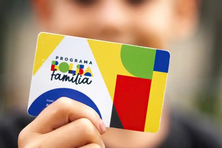 Mão segurando o cartão do Programa Bolsa Família