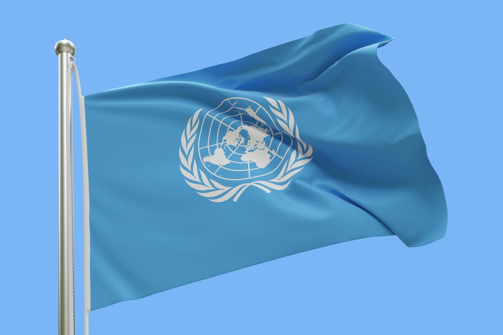 Bandeira da Organização das Nações Unidas tremulando ao vento contra o céu azul