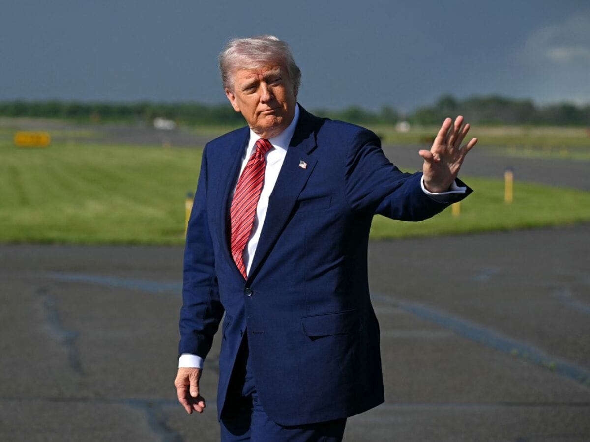 O presidente Donald Trump acena ao desembarcar em um aeroporto