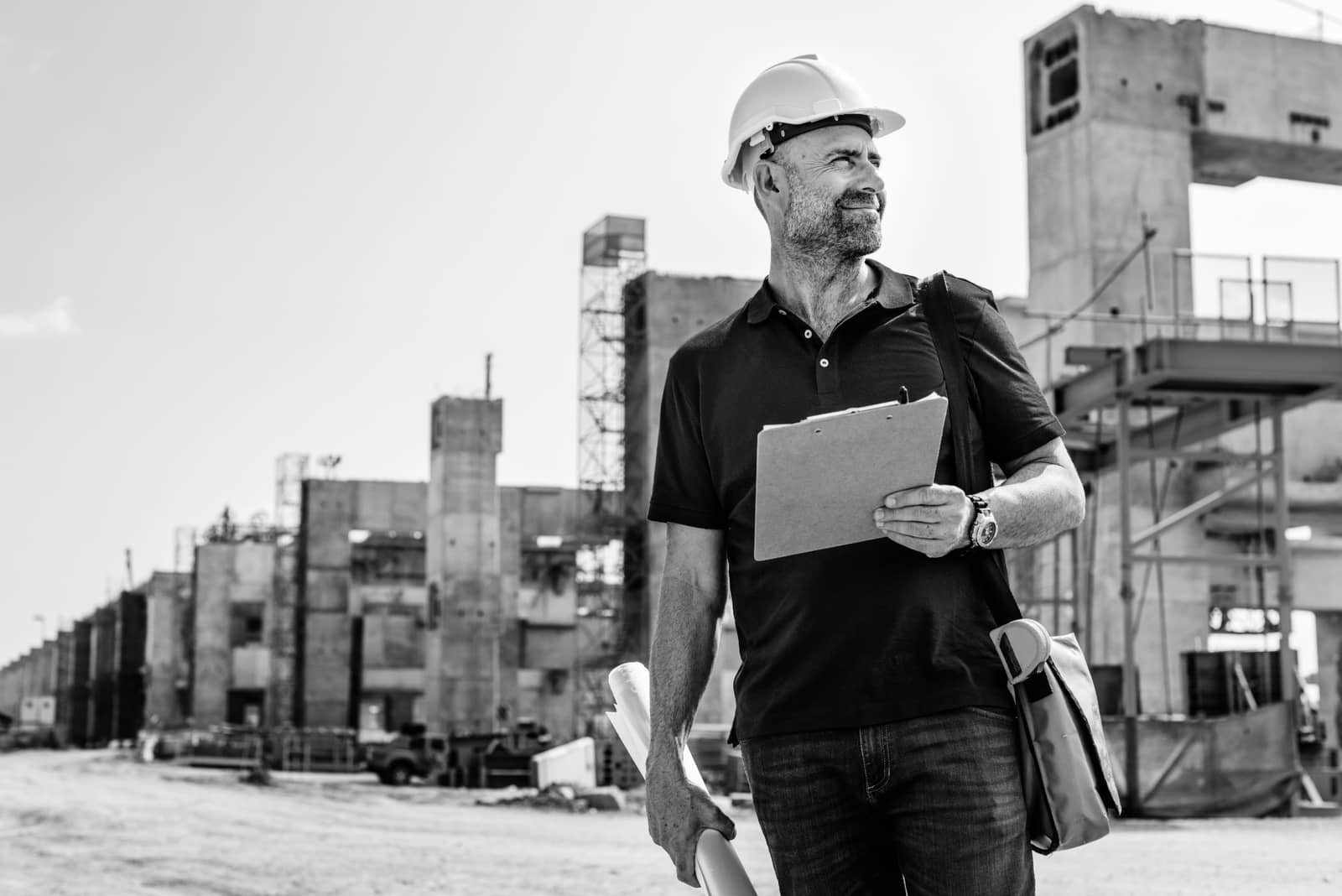 Profissional de capacete e prancheta em um canteiro de obras