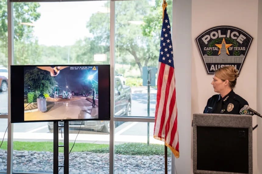 Coletiva de imprensa da polícia de Austin: uma chefe de polícia uniformizada observa, ao lado de uma bandeira dos EUA, um telão que exibe imagem de bodycam de uma cena noturna em um parque